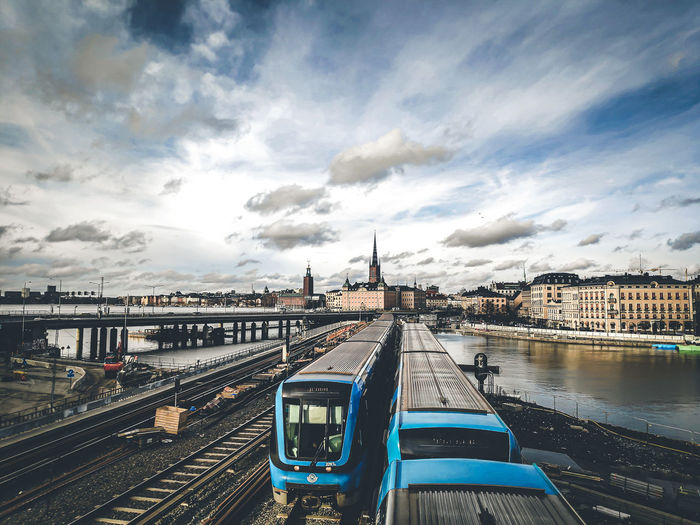 Train on bridge in city against sky