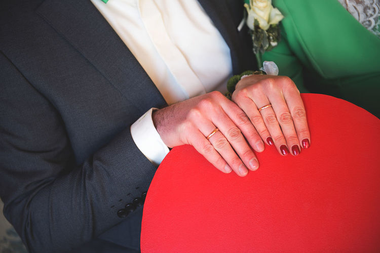 Midsection of bride and groom holding chair during wedding ceremony