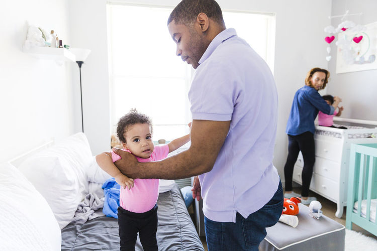 Woman looking at man holding baby girl