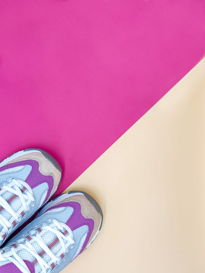 Directly above shot of shoes on pink table