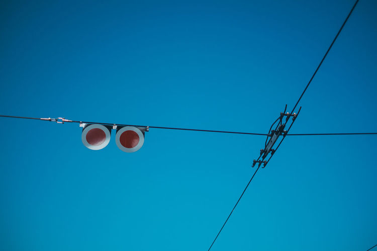 Low angle view of electricity cable against blue sky