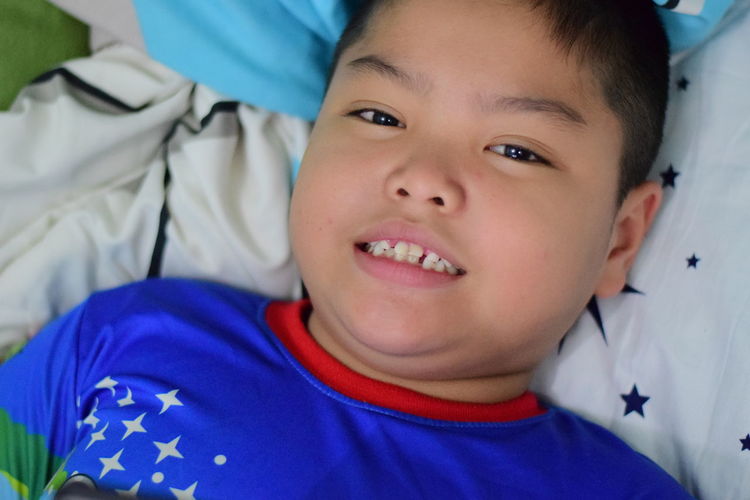 Portrait of cute smiling boy on bed