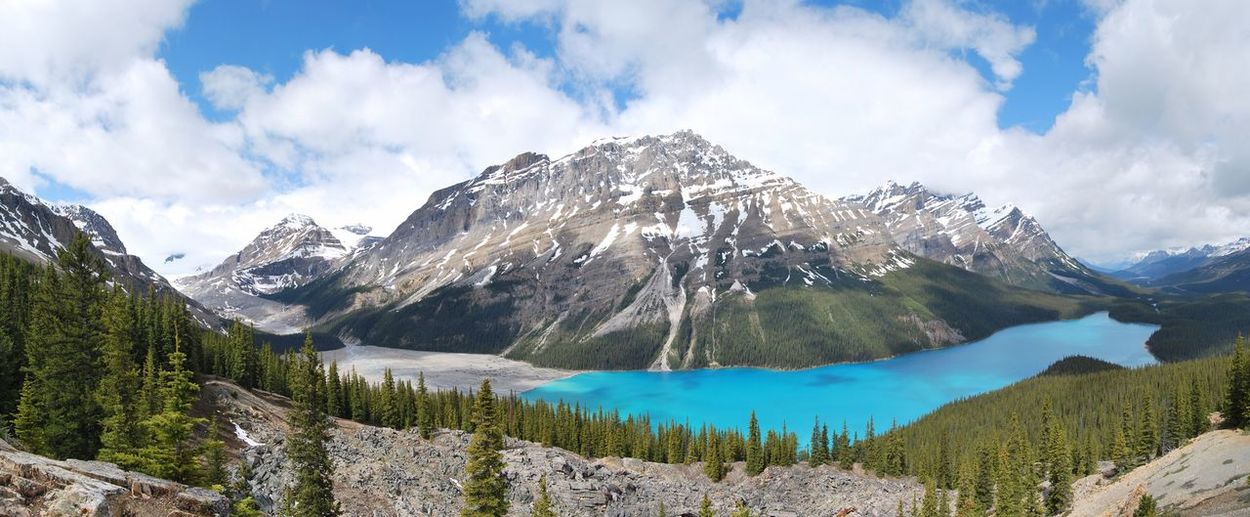 Scenic view of peyto lake by mountain against cloudy sky