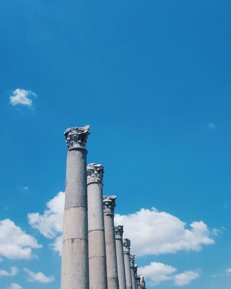 Low angle view of architectural columns against blue sky