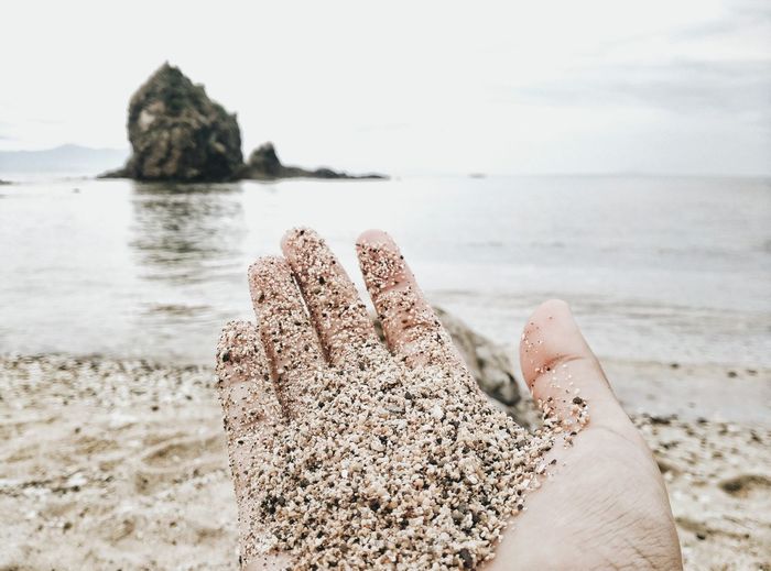 Sand covering hand of woman