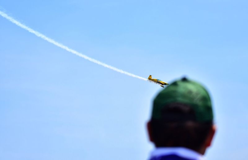 Rear view of man looking at airshow