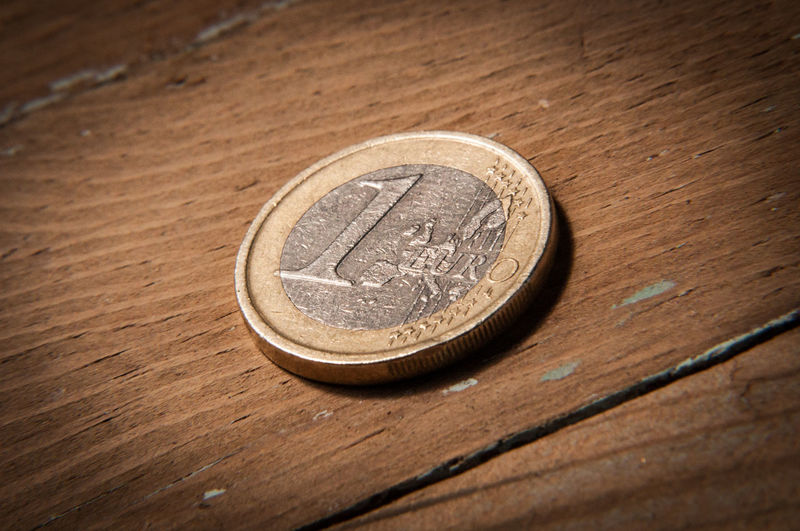 Close-up of one euro coin on wooden table