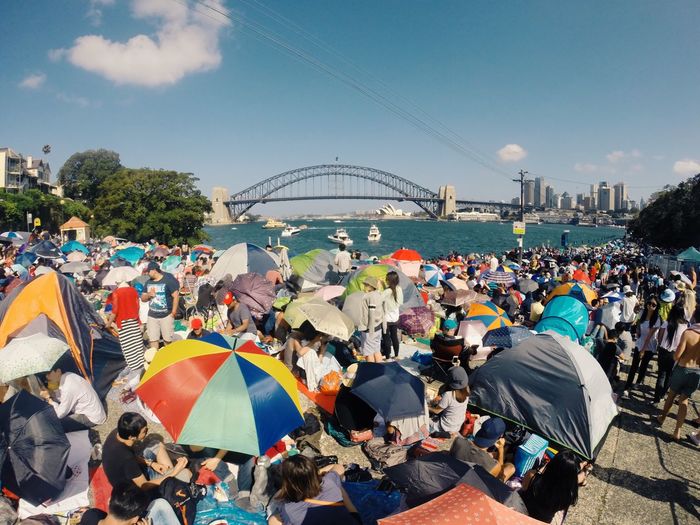 People in tent by city against sky