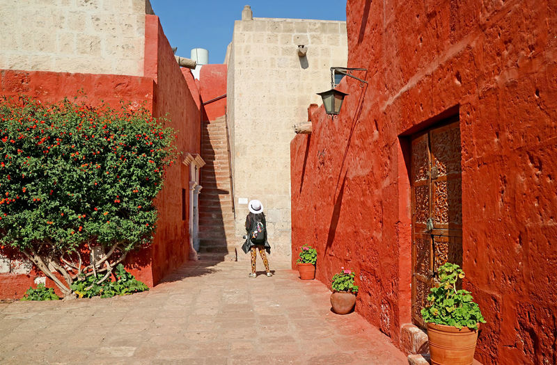 Visitor being impressed by red and white buildings in convent of santa catalina, arequipa, peru