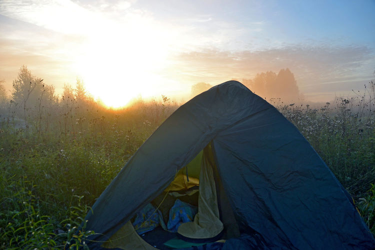 Tent on field during sunrise