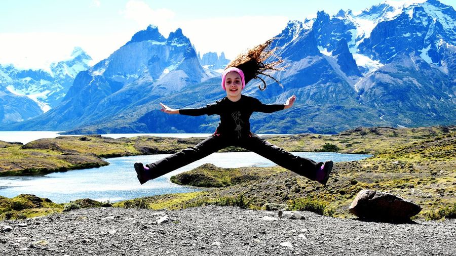 Full length of girl jumping in front of mountain