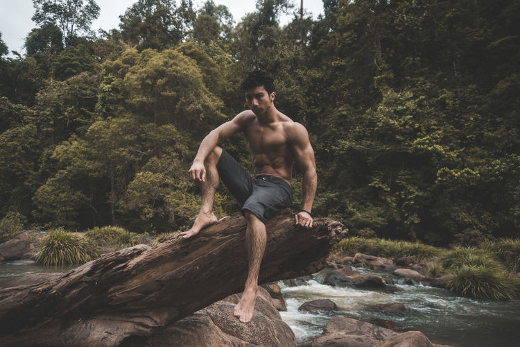 Young man on rock in forest