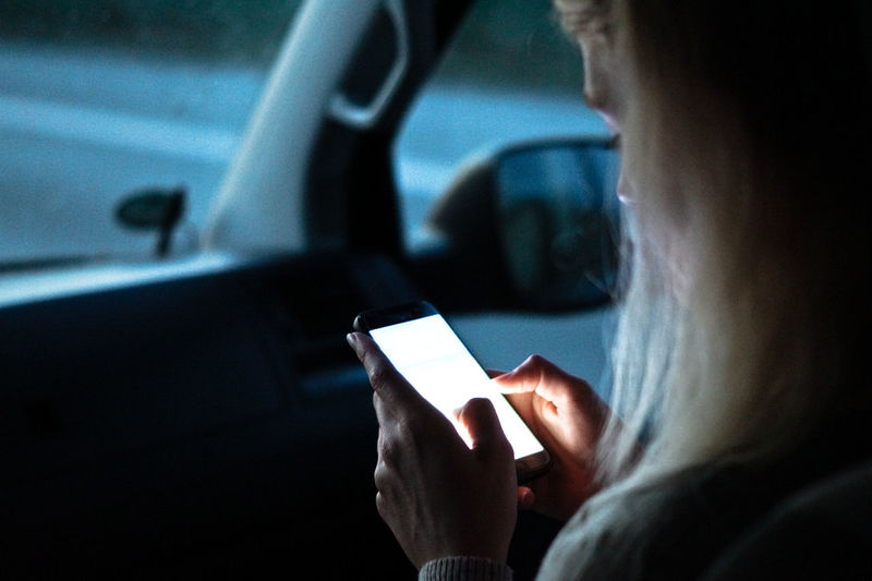 Cropped image of woman using smart phone in car