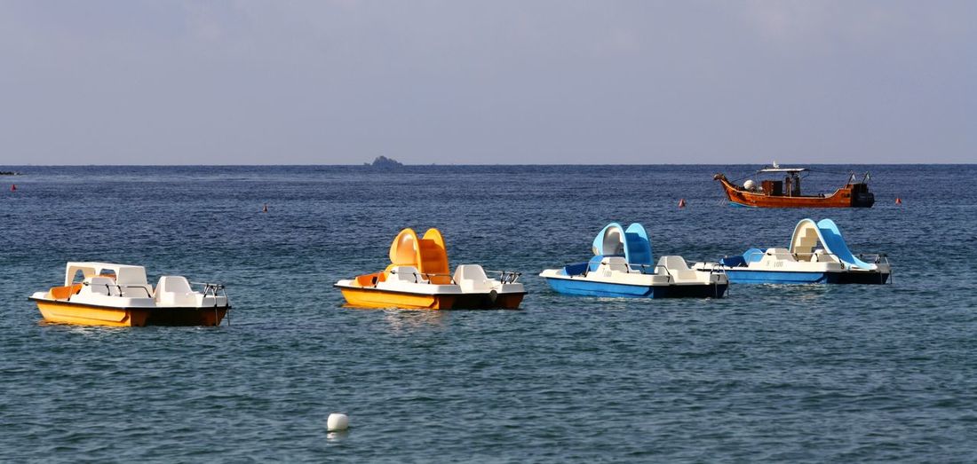 Empty boats moored on sea against sky