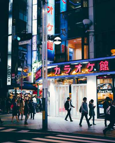People walking in city street at night