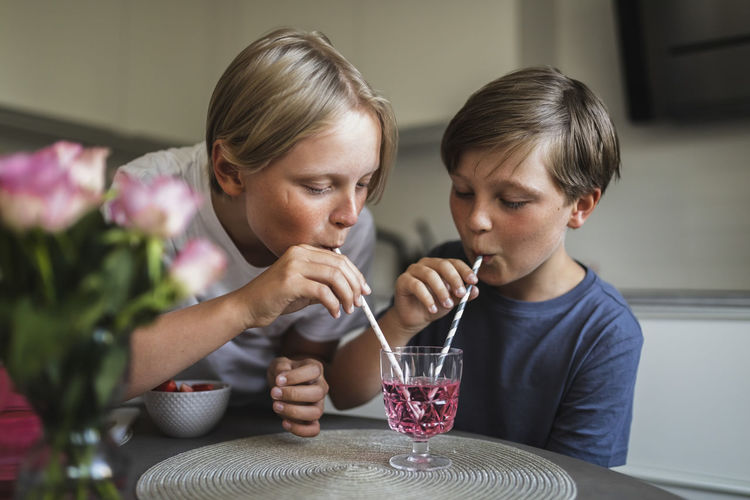 side view of girl drinking glass at home