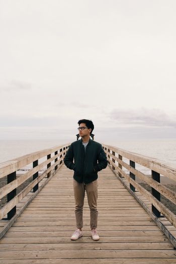Full length of man standing on pier against sky