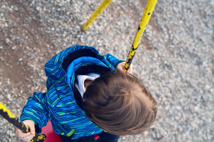 High angle view of boy swinging at playground