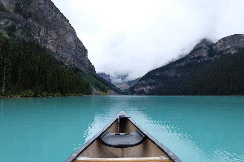 Scenic view of lake and mountains seen through boat against sky