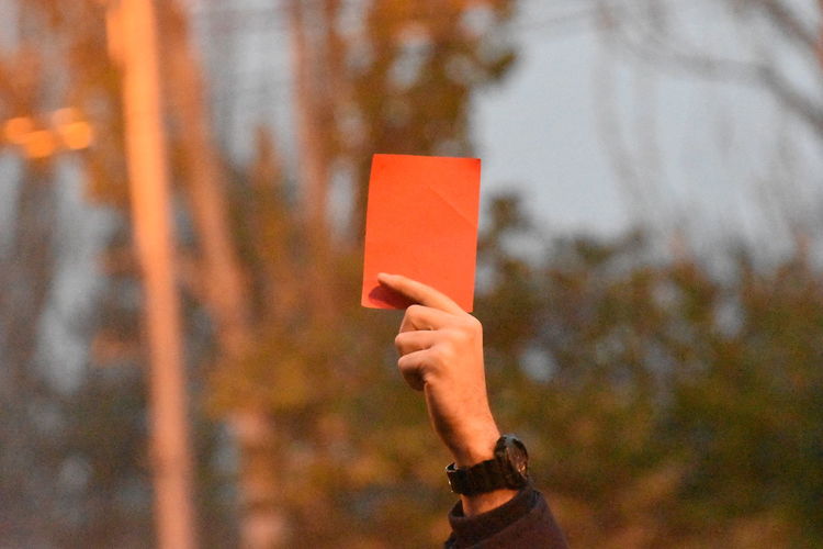 Person holding red card as a sign of protest against the government