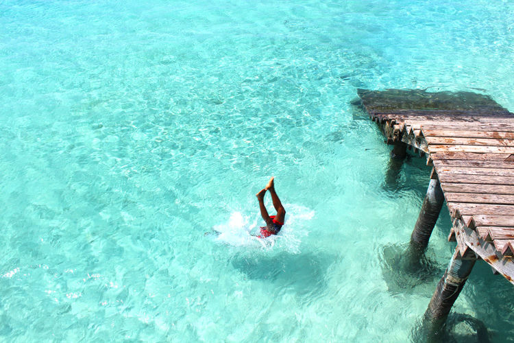 High angle view of woman jumping in sea