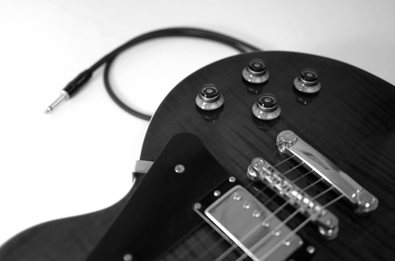 High angle view of guitar against white background