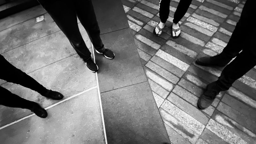 Low section of people walking on tiled floor