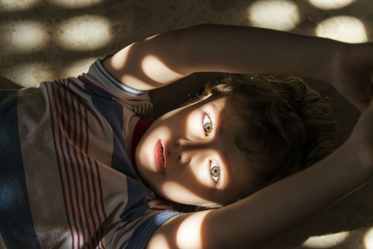Portrait of boy lying on floor at home