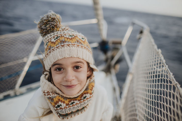 Smiling girl with knit hat traveling on boat