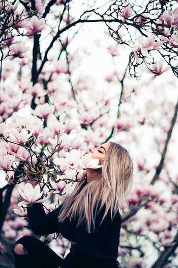 Side view of woman by flowering tree