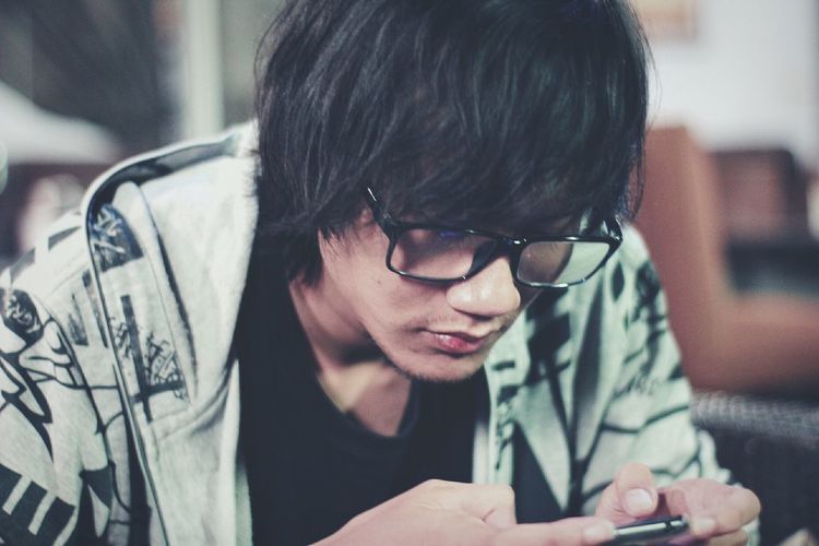 Close-up of young man using smart phone