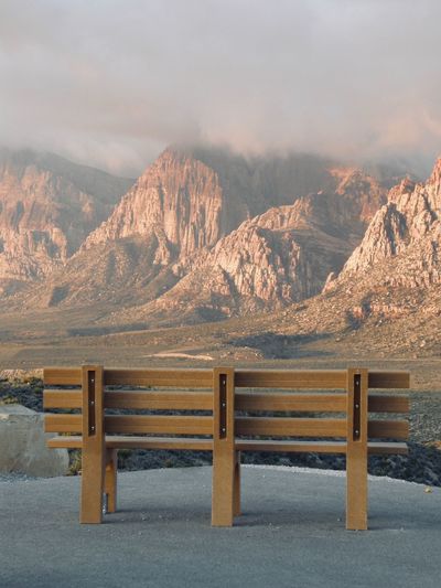 Empty bench on mountain during sunset