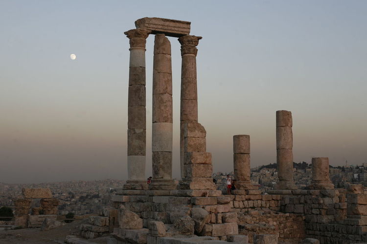 Low angle view of amman citadel seen from cave against sky during sunset
