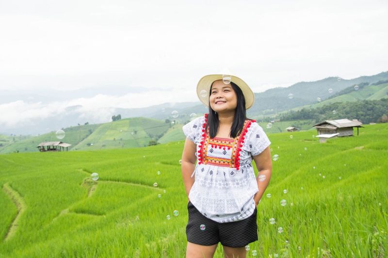 Young woman standing on rice paddy at pa bong pieng