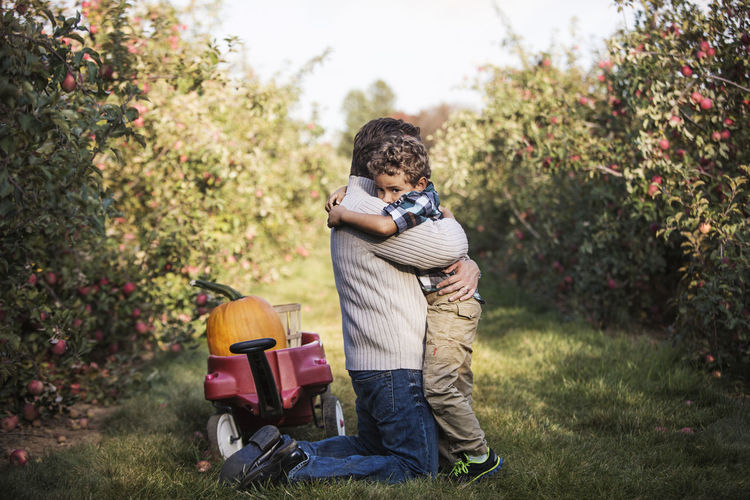 Father embracing son on grassy field
