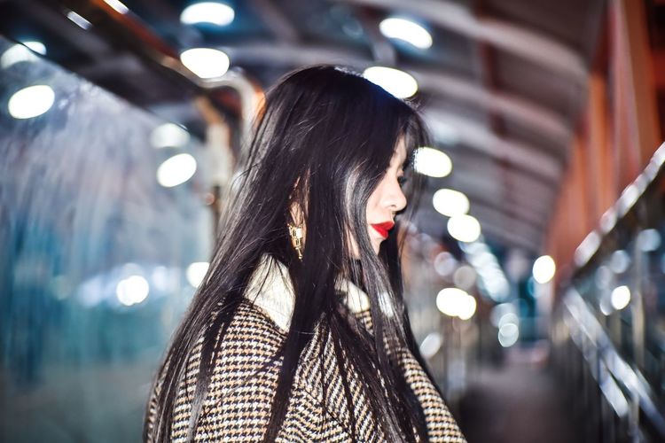 Woman standing in city at night