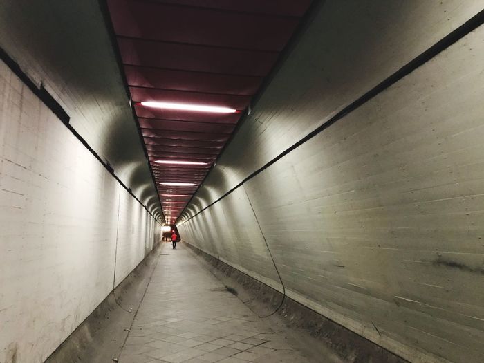 Distant view of man walking in subway tunnel