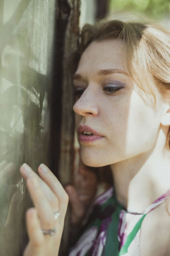 Close up pretty woman touching muddy window with fingertips portrait picture