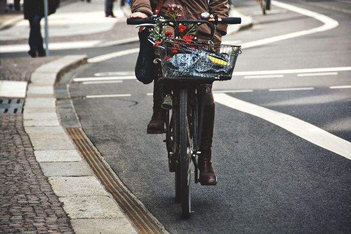 Low section of woman bicycling on road