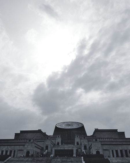 Low angle view of buildings against cloudy sky