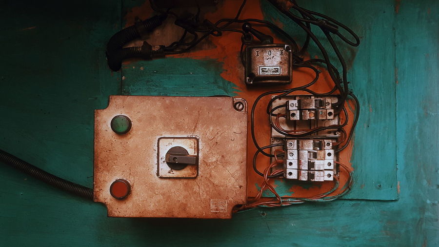 Close-up of damaged electric fuse box on wall