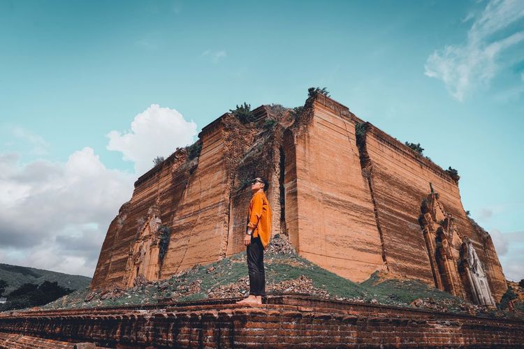 Low angle view of man standing on temple against sky