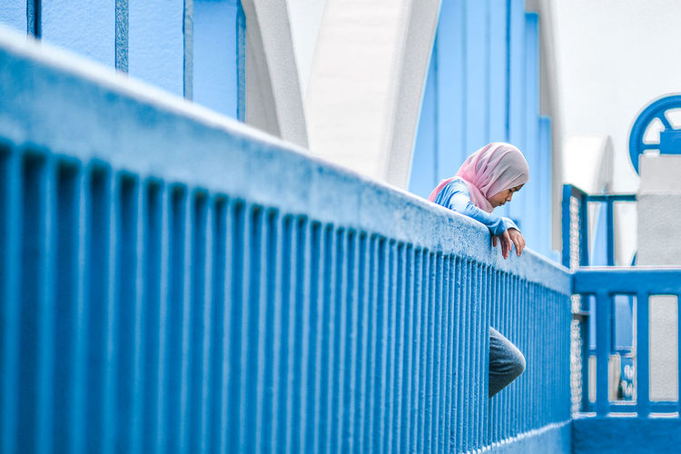 Full length of girl leaning against railing