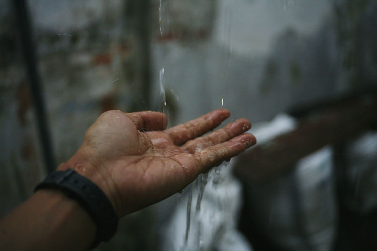 Close-up of wet hand in rainy season