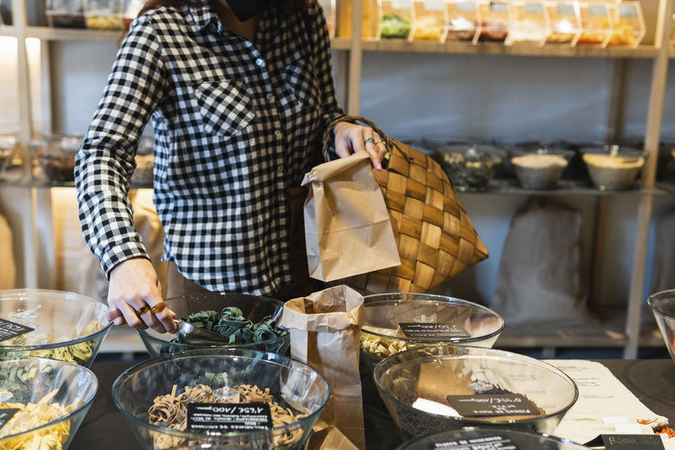Woman putting spice in paper bag at store