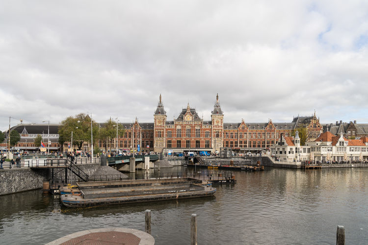View of buildings at waterfront against cloudy sky