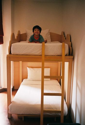 Portrait of cute boy lying on bunk bed at home