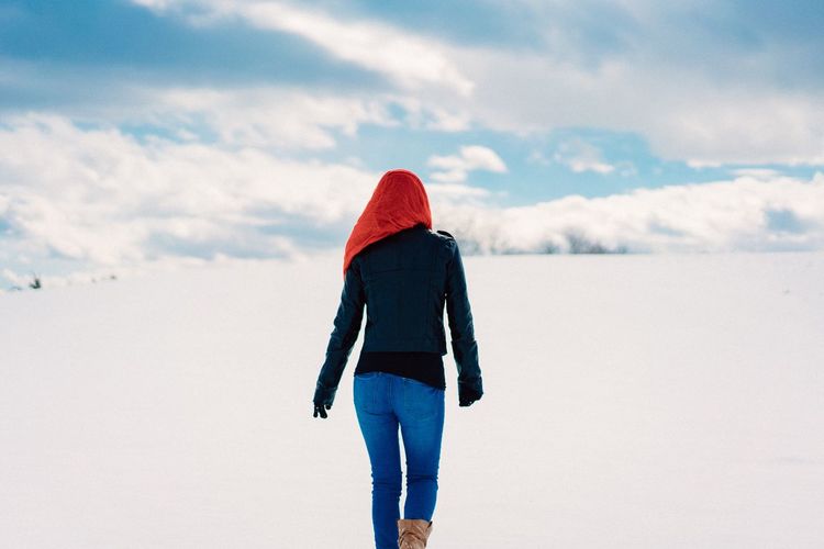 Rear view of woman walking on snow covered landscape