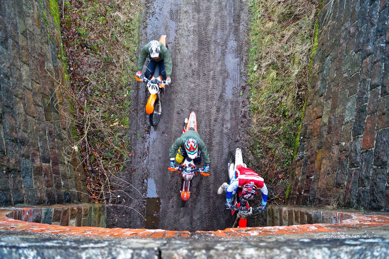 Directly above shot of men riding dirt bikes while entering tunnel