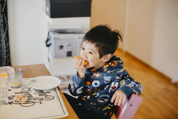 Boy at table eating fruit